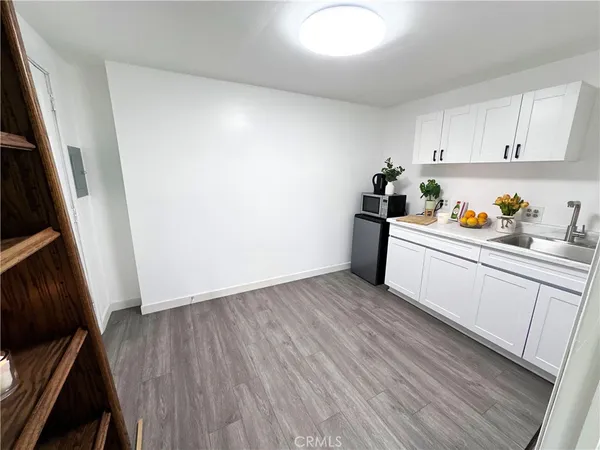 a view of a kitchen with wooden floor and electronic appliances