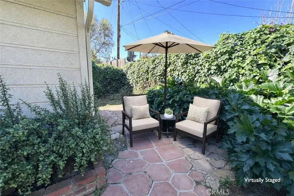 a view of a patio with furniture and a garden