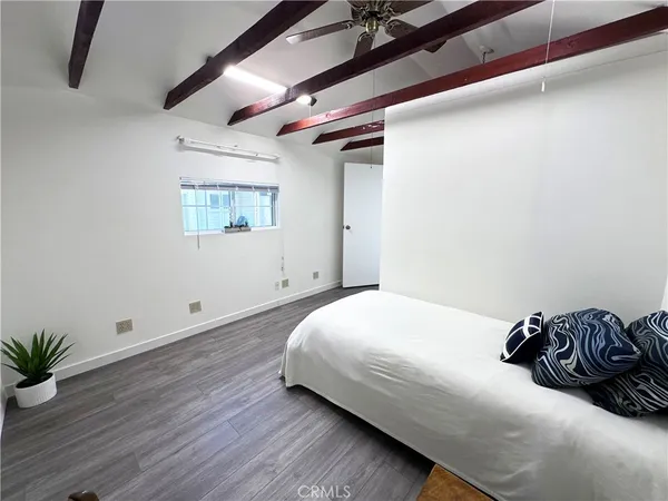 a bedroom with a bed and a potted plant