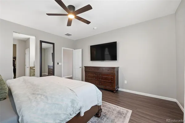 a spacious bedroom with a bed and a flat screen tv