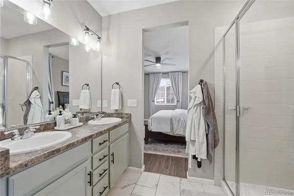 a en suite bathroom with a double vanity sink and a mirror
