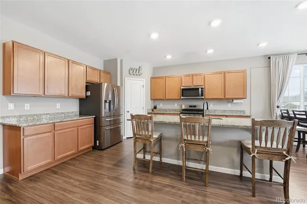 a kitchen with kitchen island granite countertop wooden floors and stainless steel appliances