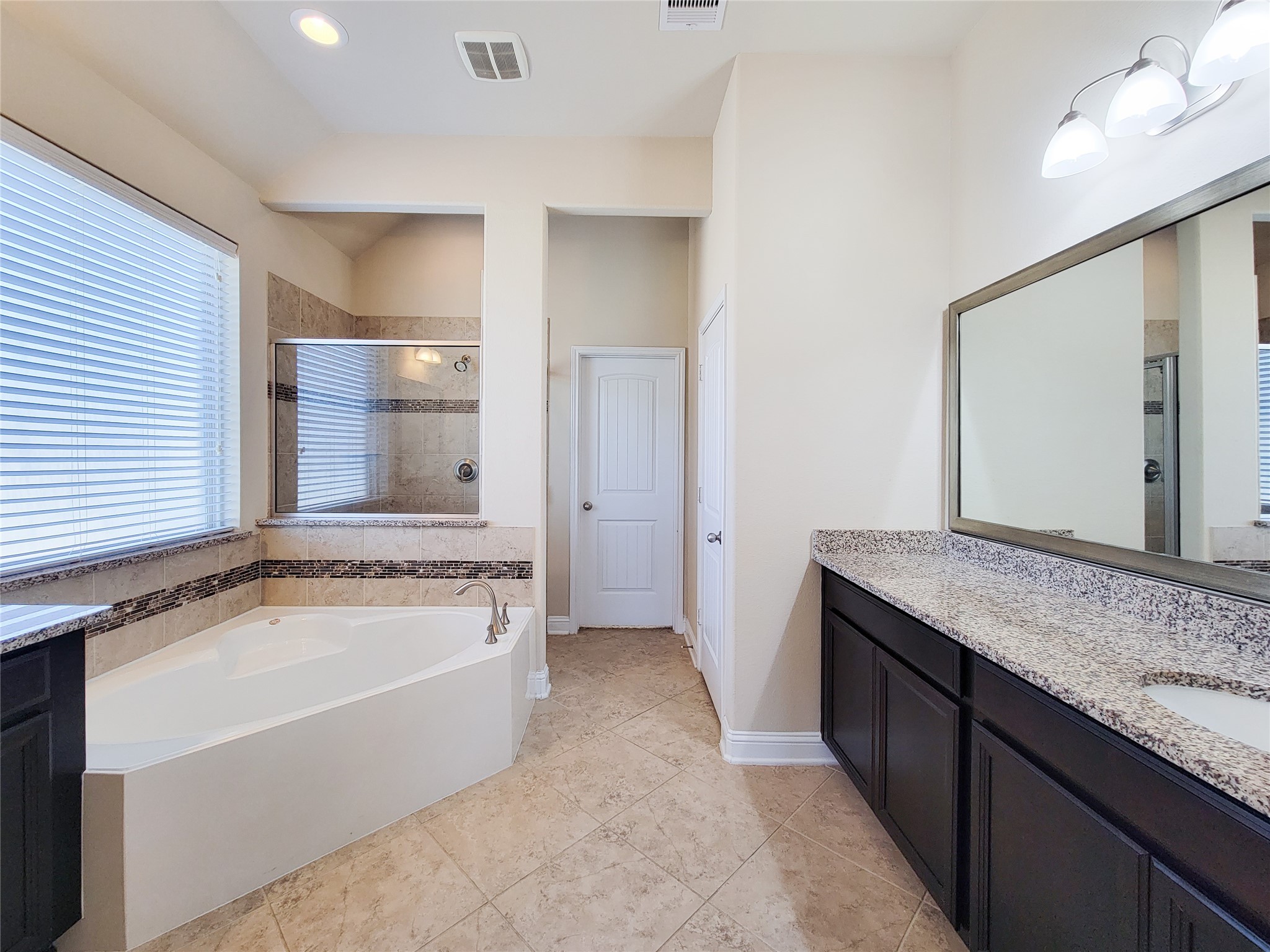 4102 Astoria Manor Lane Fulshear, TX 77441 - Photo 29 of 42 a spacious bathroom with a granite countertop tub sink and mirror