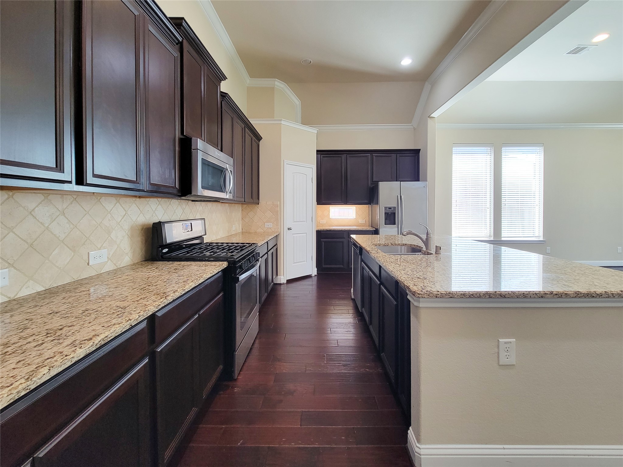 4102 Astoria Manor Lane Fulshear, TX 77441 - Photo 8 of 42 a kitchen with stainless steel appliances granite countertop a stove a sink and a refrigerator