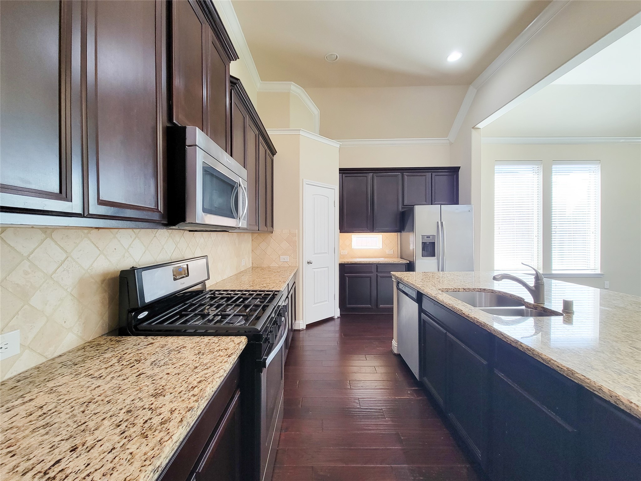 4102 Astoria Manor Lane Fulshear, TX 77441 - Photo 10 of 42 a kitchen with stainless steel appliances granite countertop a sink stove and refrigerator