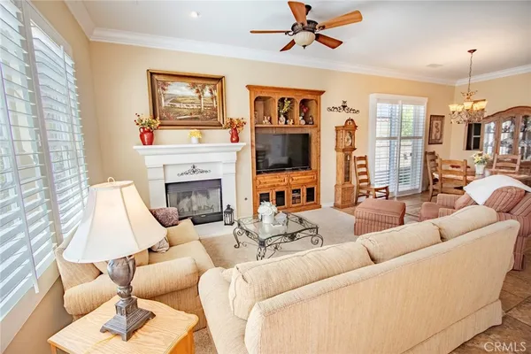 a large kitchen with stainless steel appliances a stove a refrigerator a sink and white cabinets with wooden floor
