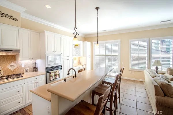 a view of a kitchen with kitchen island granite countertop a table and chairs