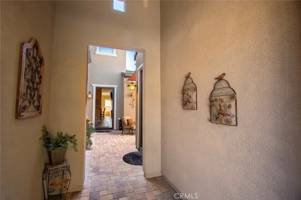 an entryway to room with wooden floor and mirror