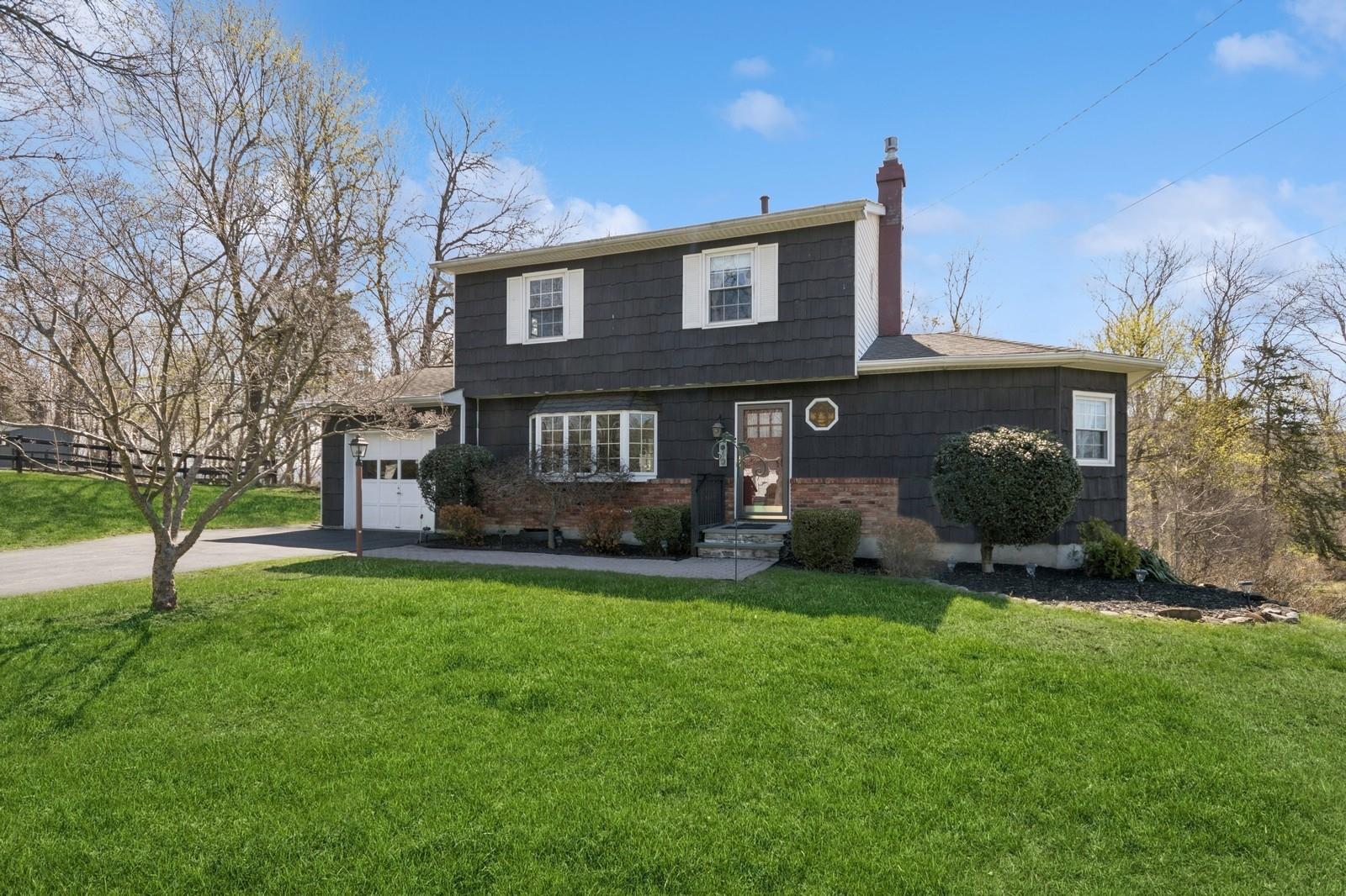 a view of a house with a yard and a tree