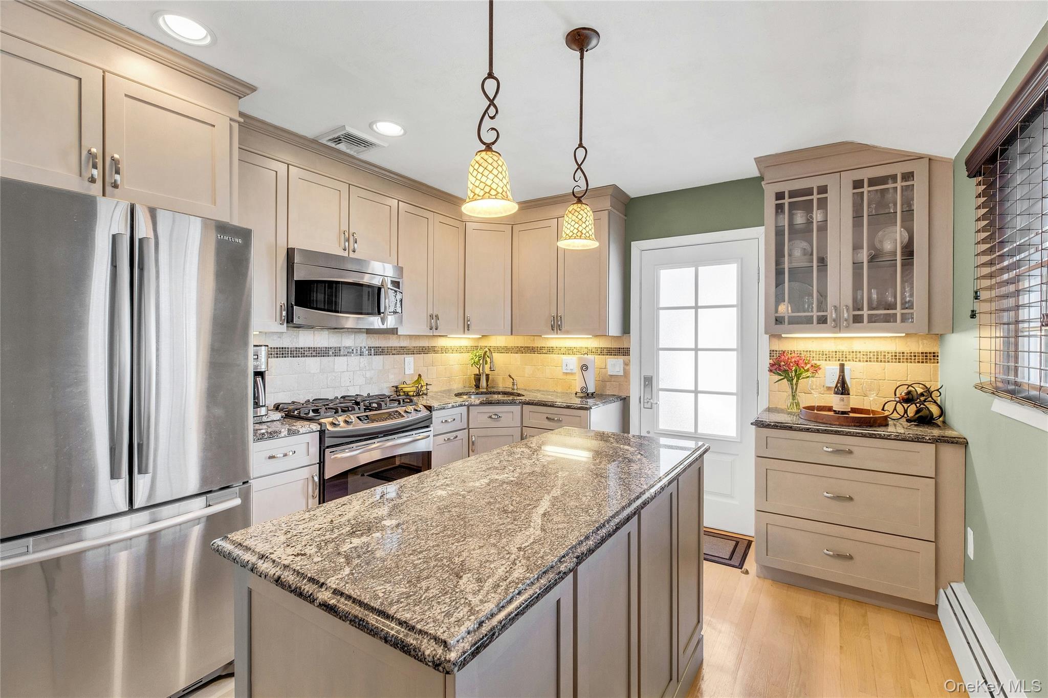 114 Lowell Road Sayville, NY 11782 - Photo 7 of 20 a kitchen with stainless steel appliances granite countertop a sink stove and refrigerator