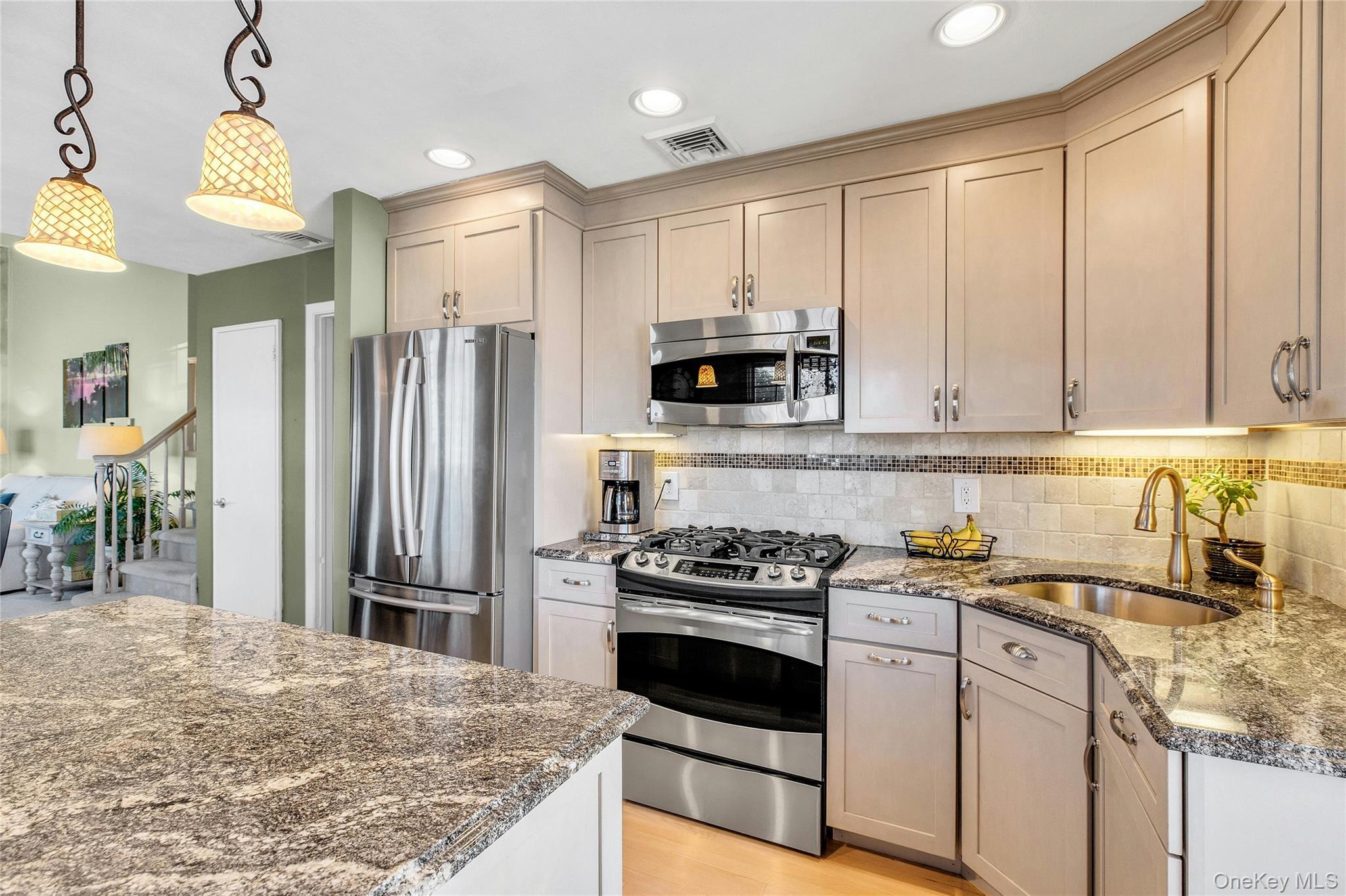 114 Lowell Road Sayville, NY 11782 - Photo 8 of 20 a kitchen with kitchen island granite countertop a stove a sink and a refrigerator with wooden floor