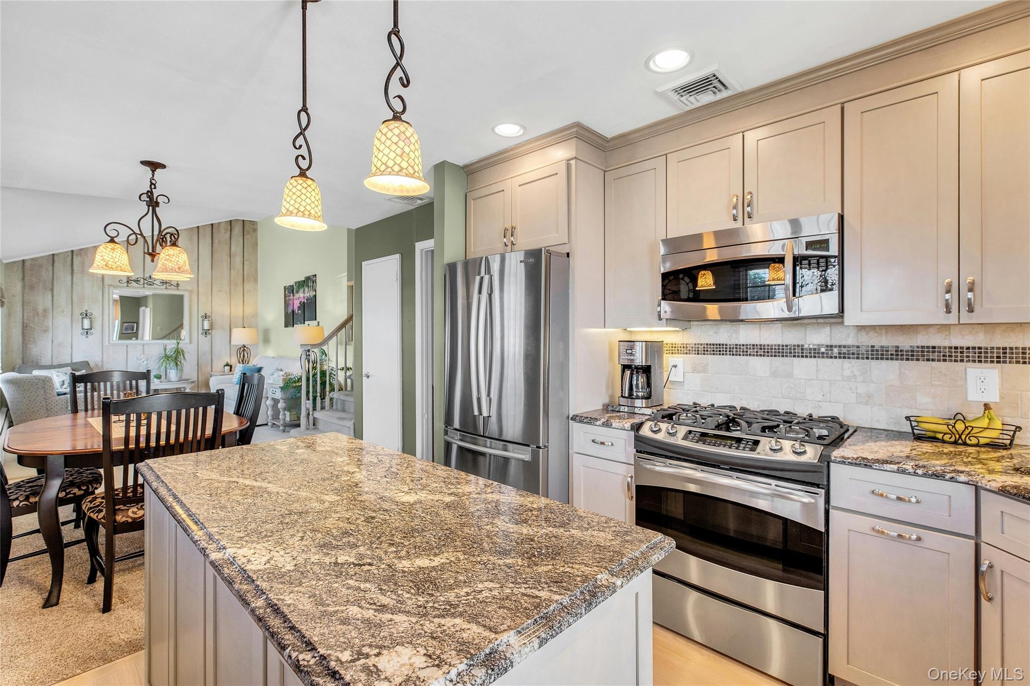 114 Lowell Road Sayville, NY 11782 - Photo 9 of 20 a kitchen with kitchen island granite countertop a stove a sink a refrigerator wooden floor and white cabinets