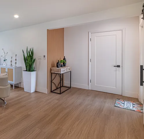 a kitchen with kitchen island granite countertop a table chairs refrigerator and microwave