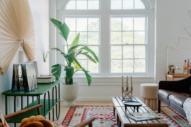 a living room with furniture a rug and a large window
