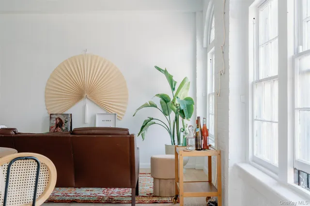 a white bed sitting in a bedroom next to a window