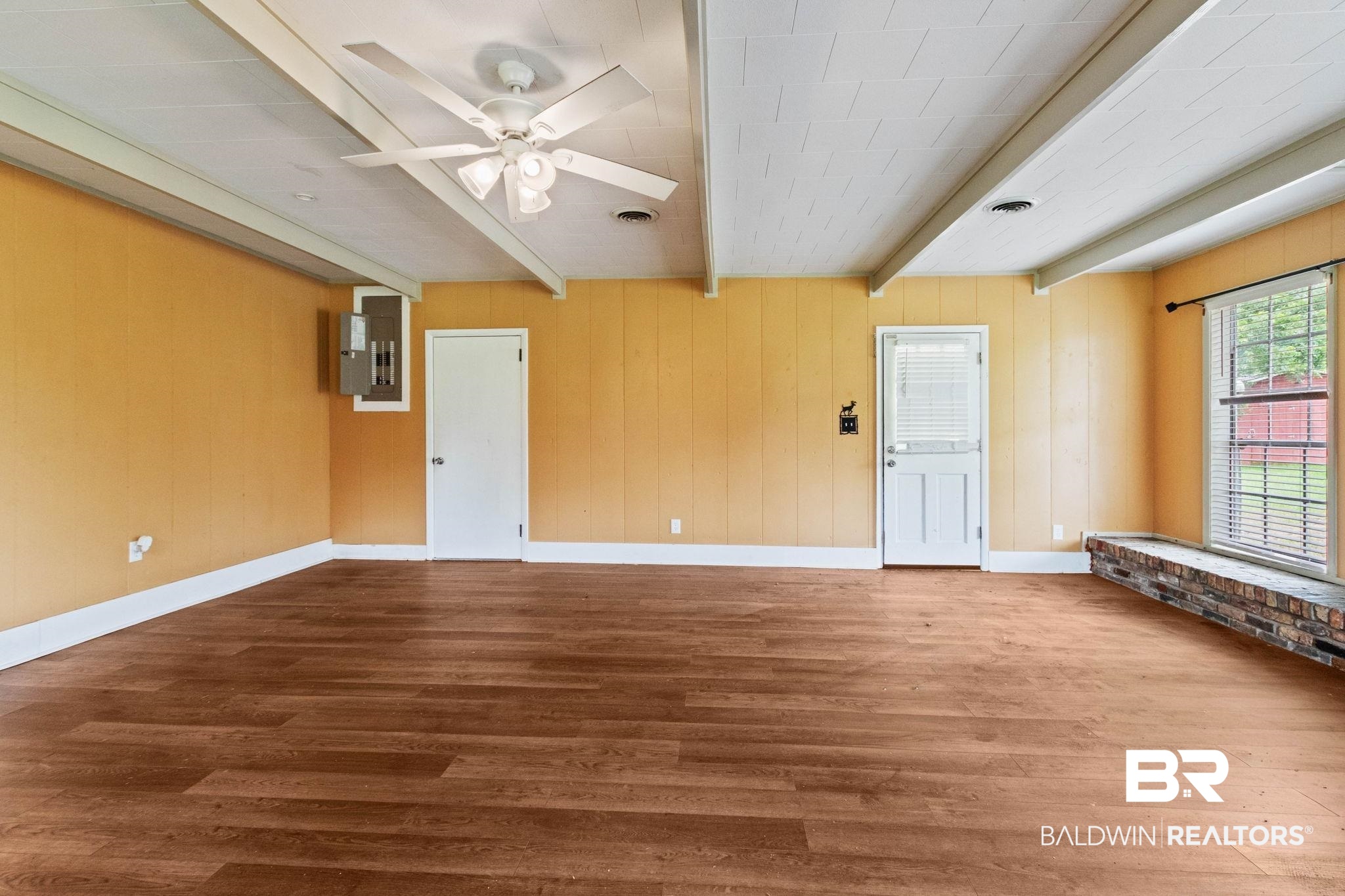 384 Old Bratt Road Atmore, AL 36502 - Photo 11 of 64 Spacious room featuring wood-finish flooring, exposed ceiling beams, and a ceiling fan with integrated lighting