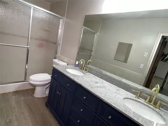 a bathroom with a double vanity sink toilet and mirror