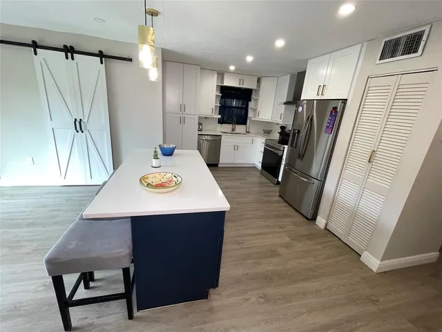 a kitchen with kitchen island a refrigerator a stove a sink and a oven