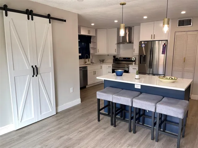 a kitchen with a table chairs refrigerator and microwave