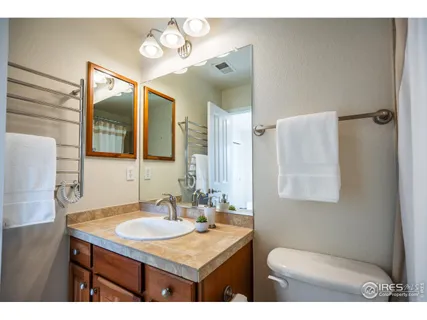 a bathroom with a granite countertop sink toilet and mirror