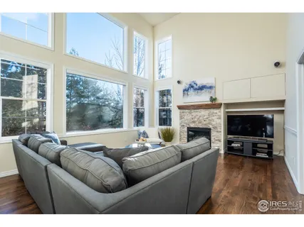 a living room with furniture fireplace and a large window