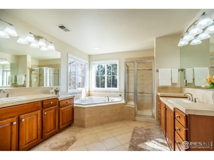 a large bathroom with a tub double vanity sink and a mirror