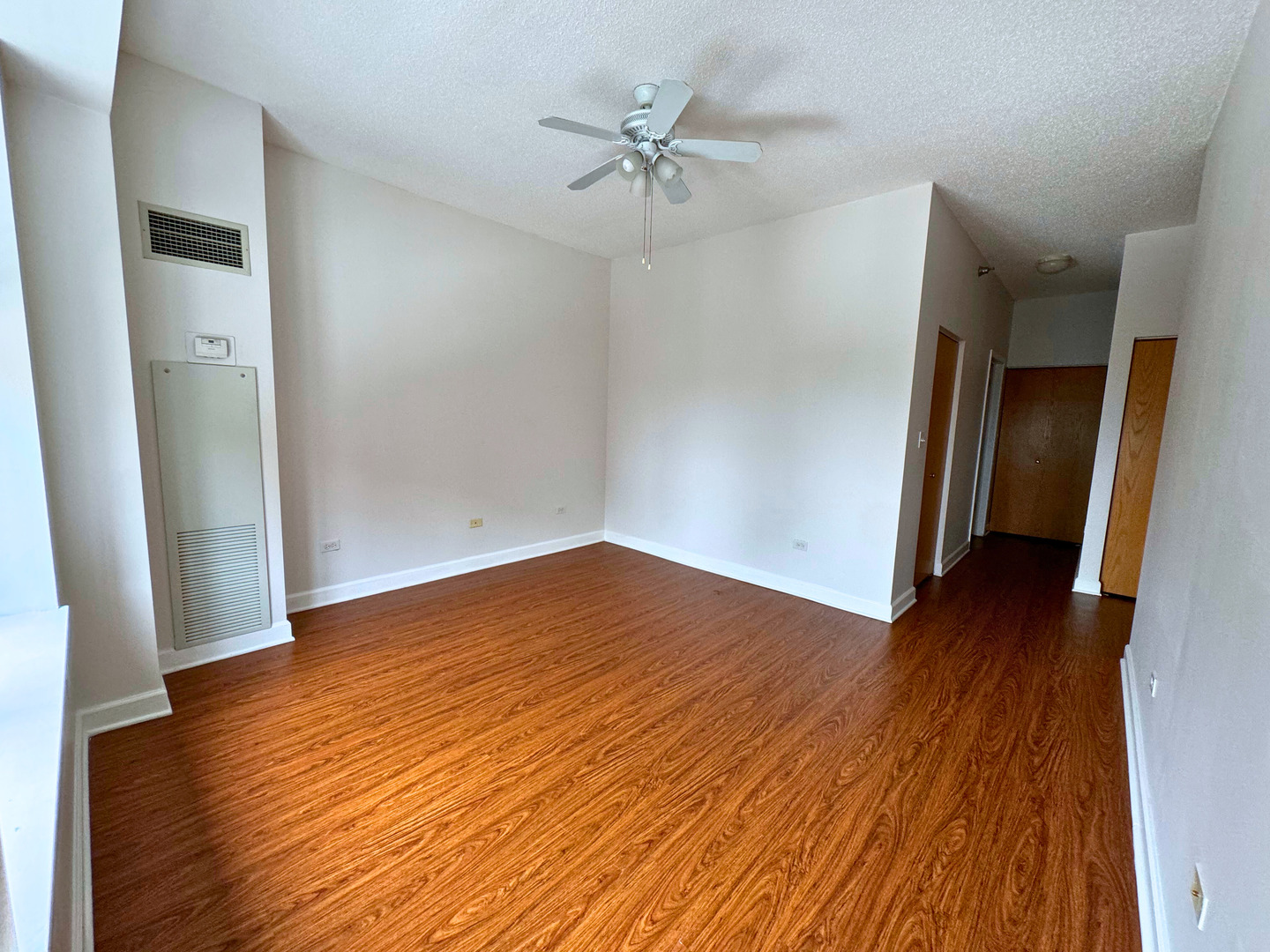 41 East 8th Street, Unit 1702 Chicago, IL 60605 - Photo 11 of 20 an empty room with wooden floor and a ceiling fan
