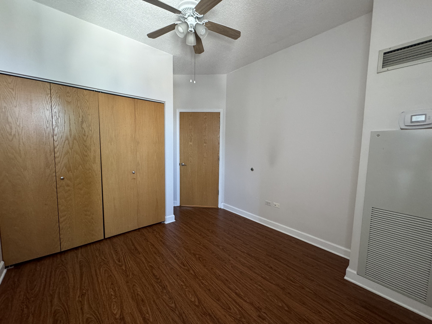 41 East 8th Street, Unit 1702 Chicago, IL 60605 - Photo 15 of 20 an empty room with wooden floor fan and windows