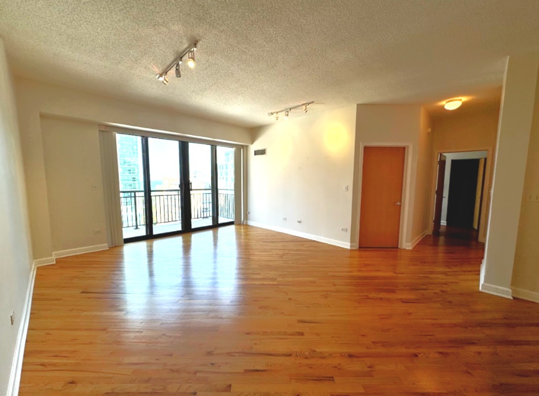41 East 8th Street, Unit 1702 Chicago, IL 60605 - Photo 4 of 20 a view of an empty room with wooden floor and a window