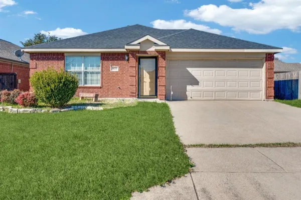 a front view of a house with a yard and a garage