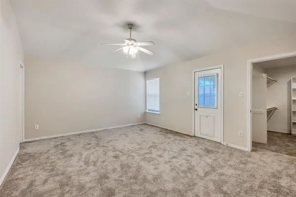 an empty room with windows and fan