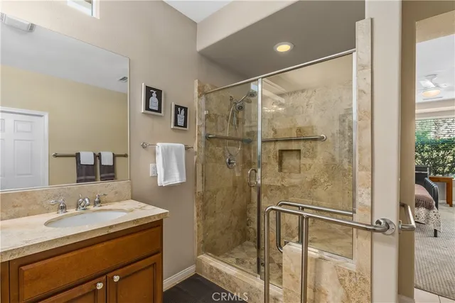 a bathroom with a granite countertop sink a mirror and shower