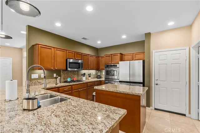 a kitchen with stainless steel appliances granite countertop a sink refrigerator and microwave