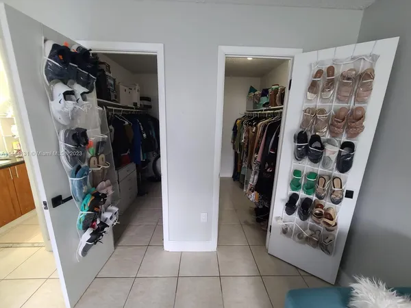 a view of walk in closet with clothes and shoes