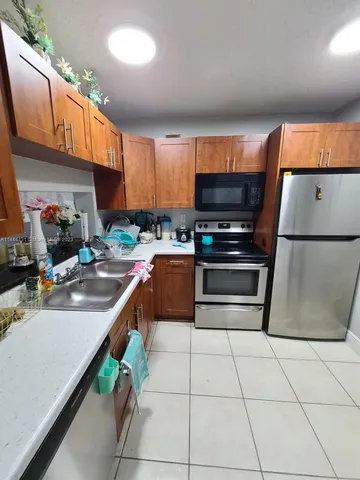 a kitchen with stainless steel appliances a stove a sink and a microwave