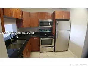 a kitchen with a refrigerator a stove a sink and a microwave