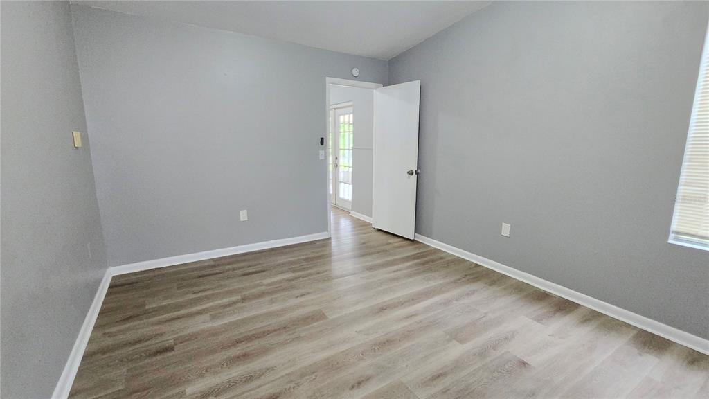 3410 15th Street Southwest Lehigh Acres, FL 33976 - Photo 15 of 31 an empty room with wooden floor and windows