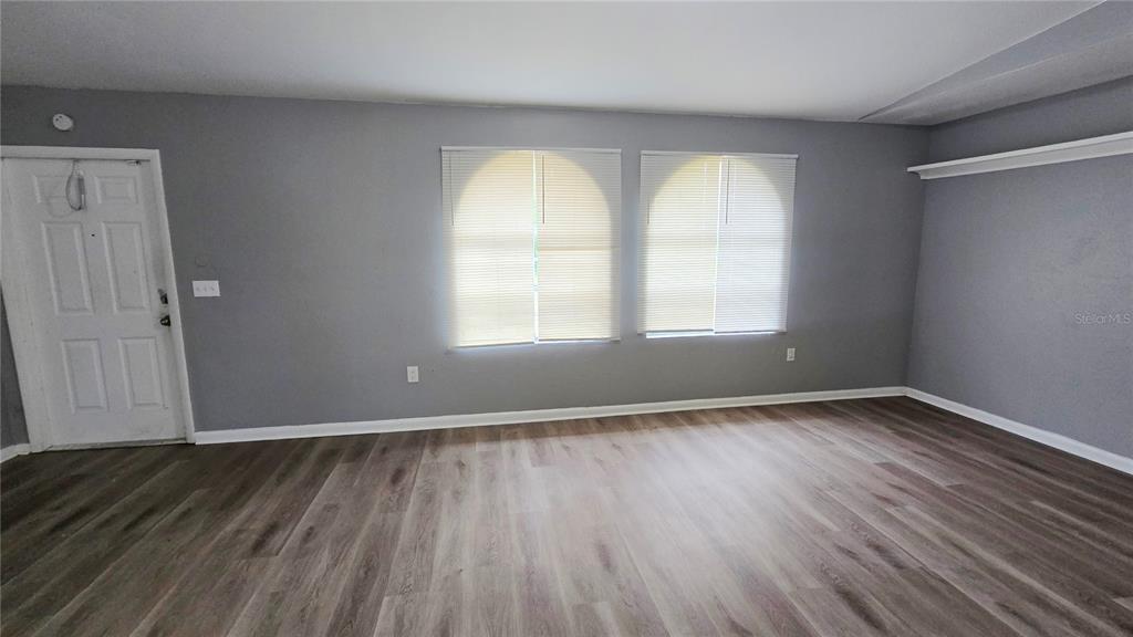3410 15th Street Southwest Lehigh Acres, FL 33976 - Photo 18 of 31 an empty room with wooden floor and windows
