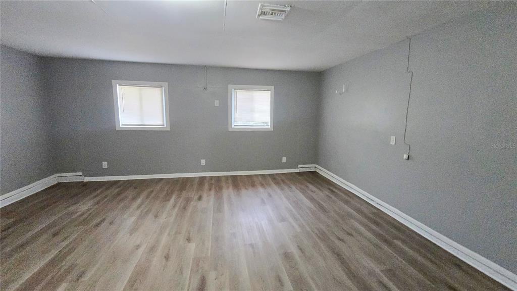 3410 15th Street Southwest Lehigh Acres, FL 33976 - Photo 19 of 31 an empty room with wooden floor and windows