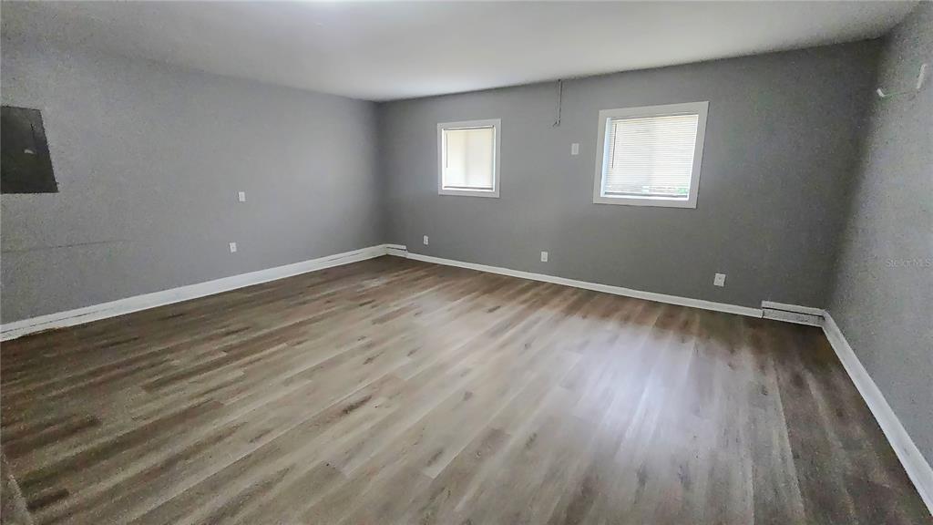 3410 15th Street Southwest Lehigh Acres, FL 33976 - Photo 24 of 31 a view of an empty room with wooden floor and a window