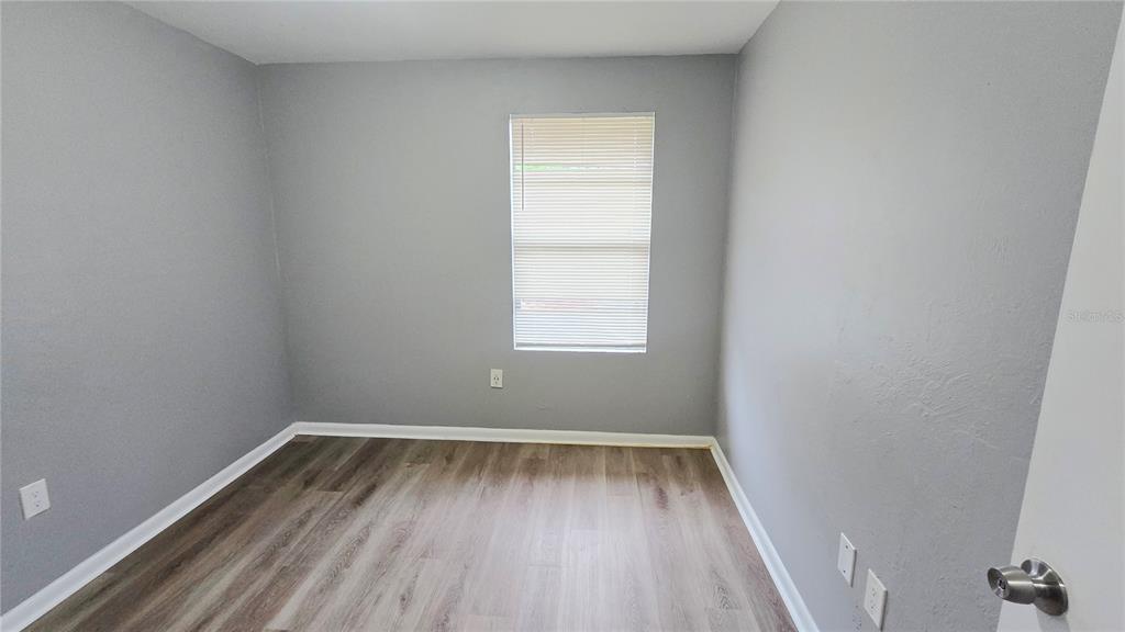 3410 15th Street Southwest Lehigh Acres, FL 33976 - Photo 27 of 31 a view of room with window and hardwood floor