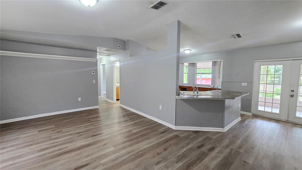 3410 15th Street Southwest Lehigh Acres, FL 33976 - Photo 5 of 31 an empty room with wooden floor and windows
