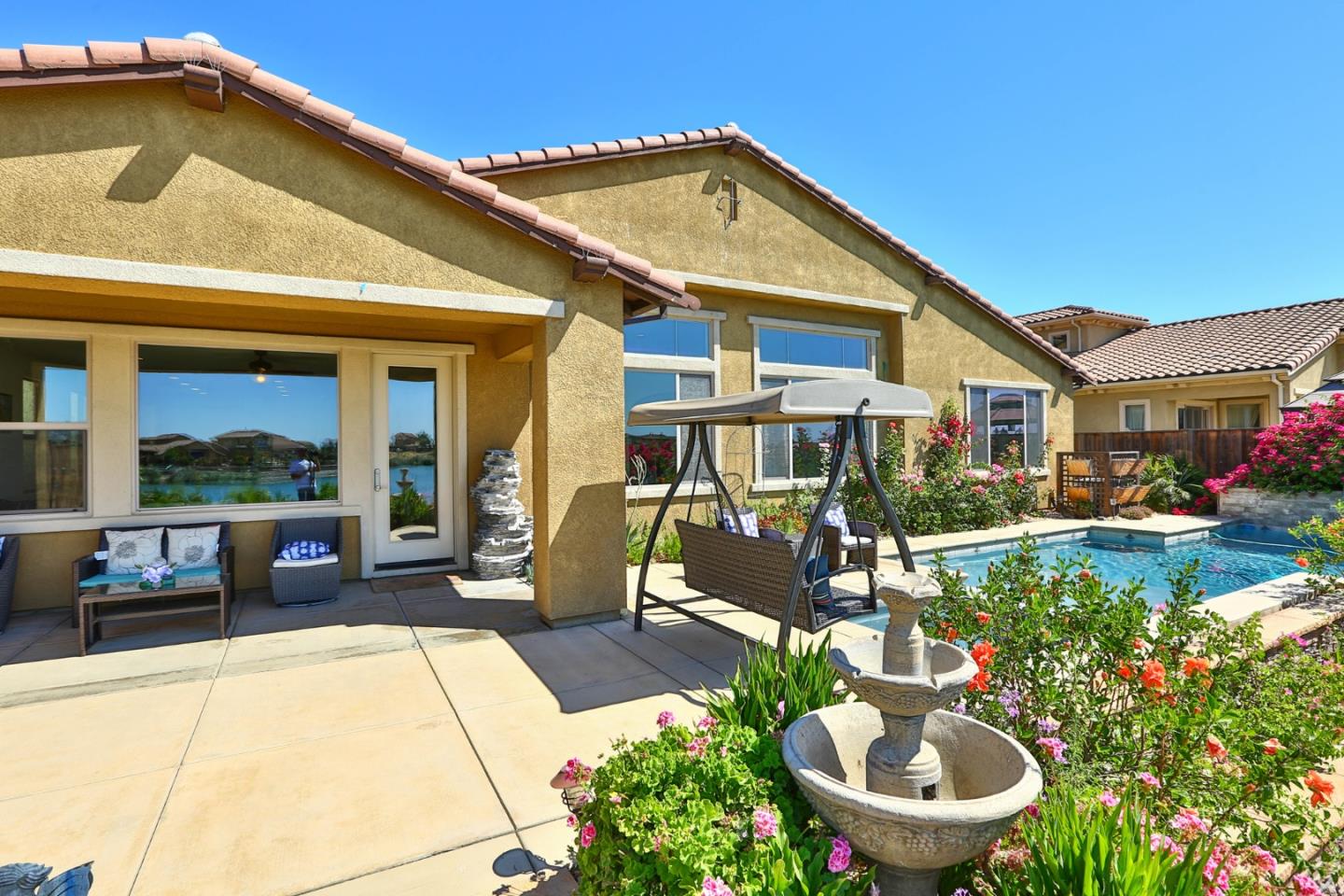 4192 Chiavari Way Manteca, CA 95337 - Photo 21 of 67 a view of a patio with couches table and chairs potted plants and palm tree