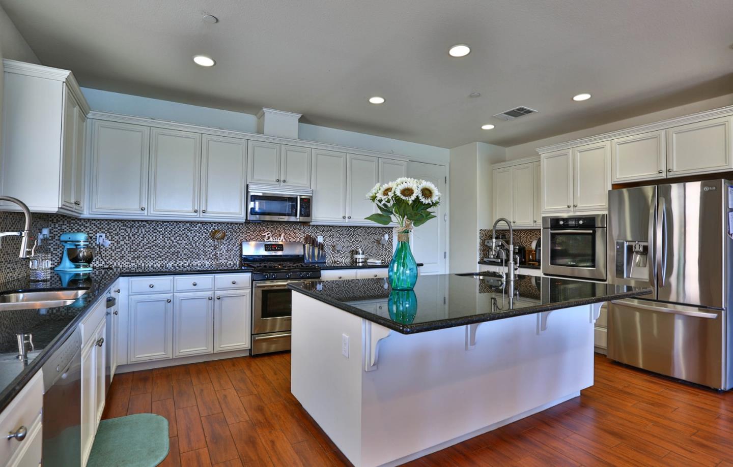 4192 Chiavari Way Manteca, CA 95337 - Photo 28 of 67 a living room with stainless steel appliances granite countertop a couch a stove a sink a refrigerator and cabinets