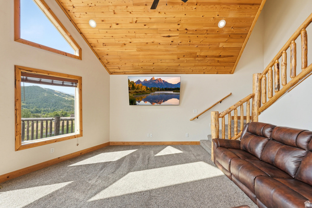 306 Spring Road Preston, ID 83263 - Photo 6 of 55 Carpeted living space featuring a wood-plank ceiling, natural wood trim windows, and a rustic log staircase