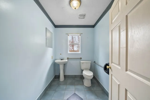 a view of a kitchen with a sink and an empty room