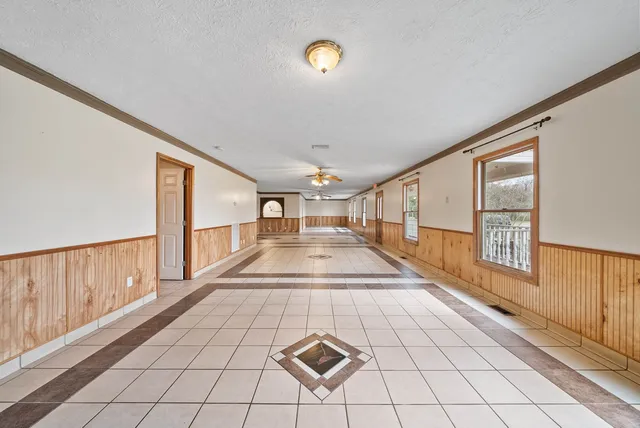 a view of an empty room and window chandelier fan