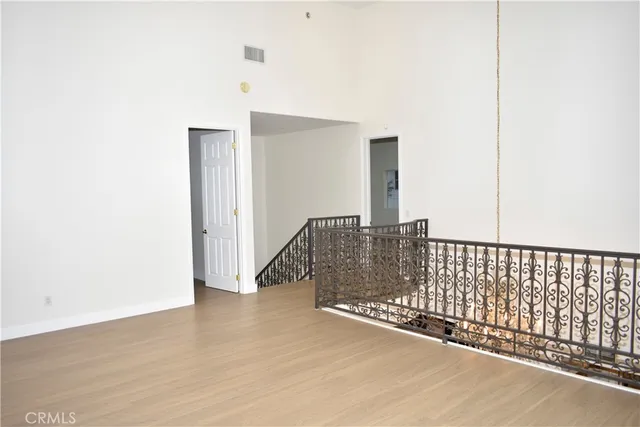 a view of an empty room with wooden floor and windows