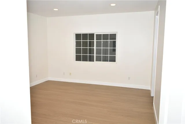 a view of an empty room with a window and fire place