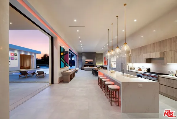 a large kitchen with a large counter top appliances and a living room view